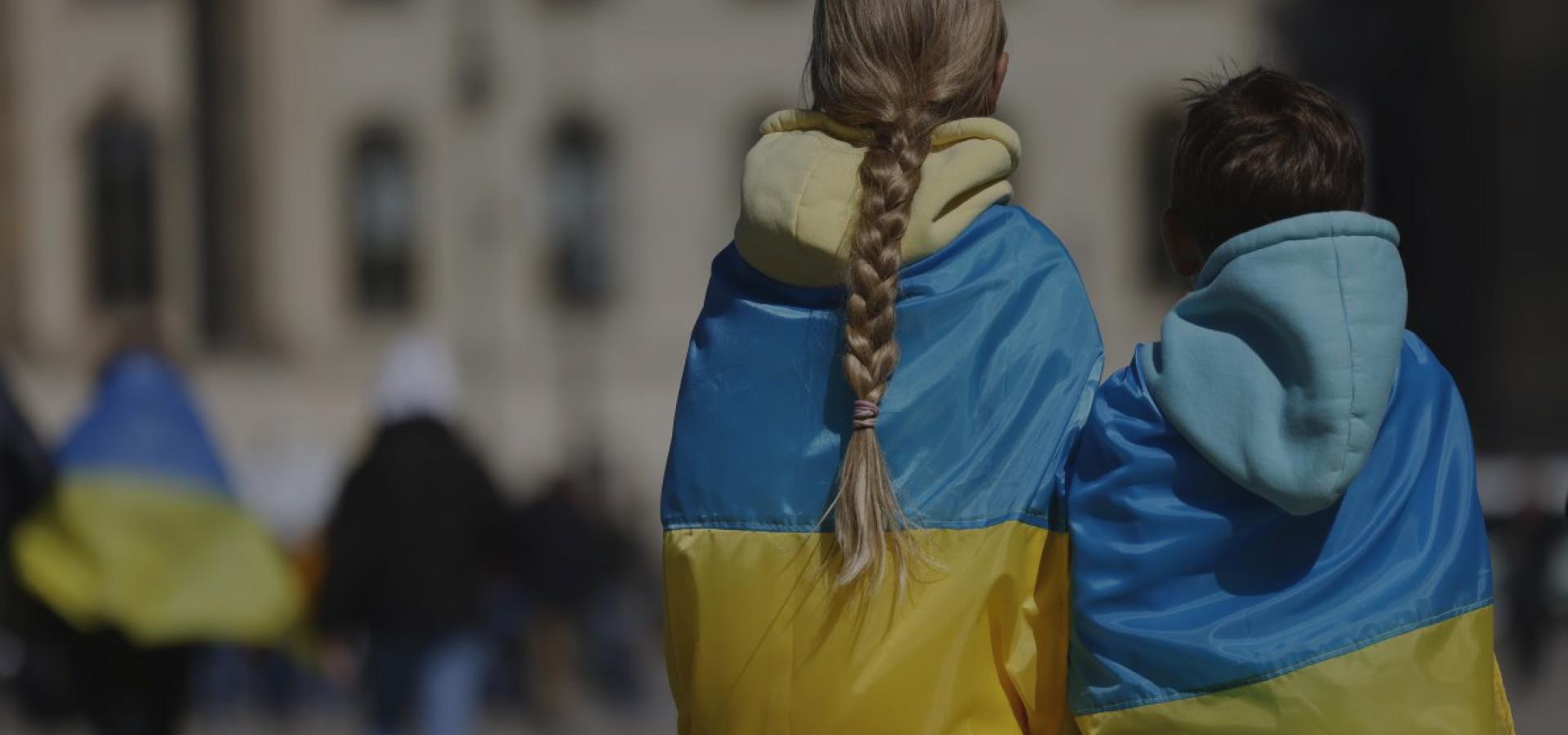 Children wrapped in Ukrainian flags