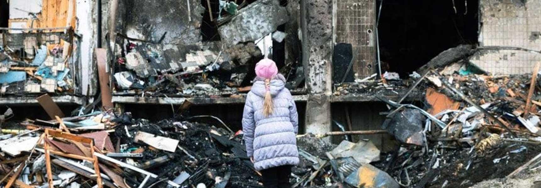 A child standing inside a war-damaged building in Ukraine