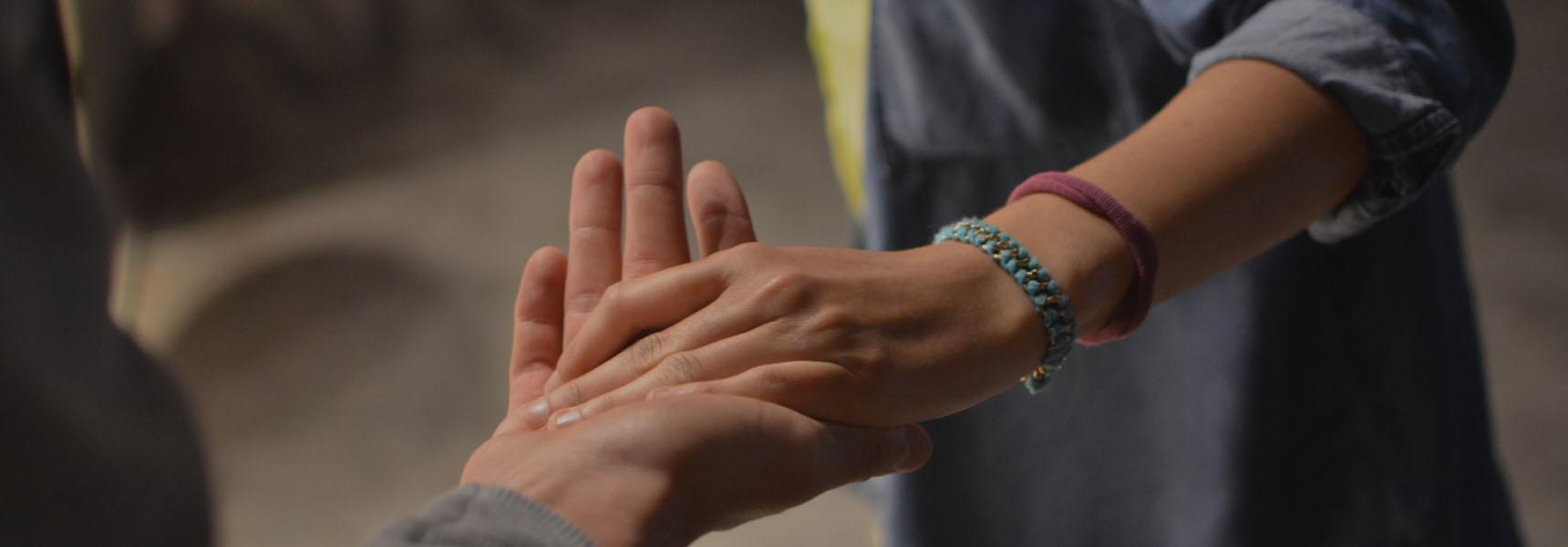 A group of people joining hands in support
