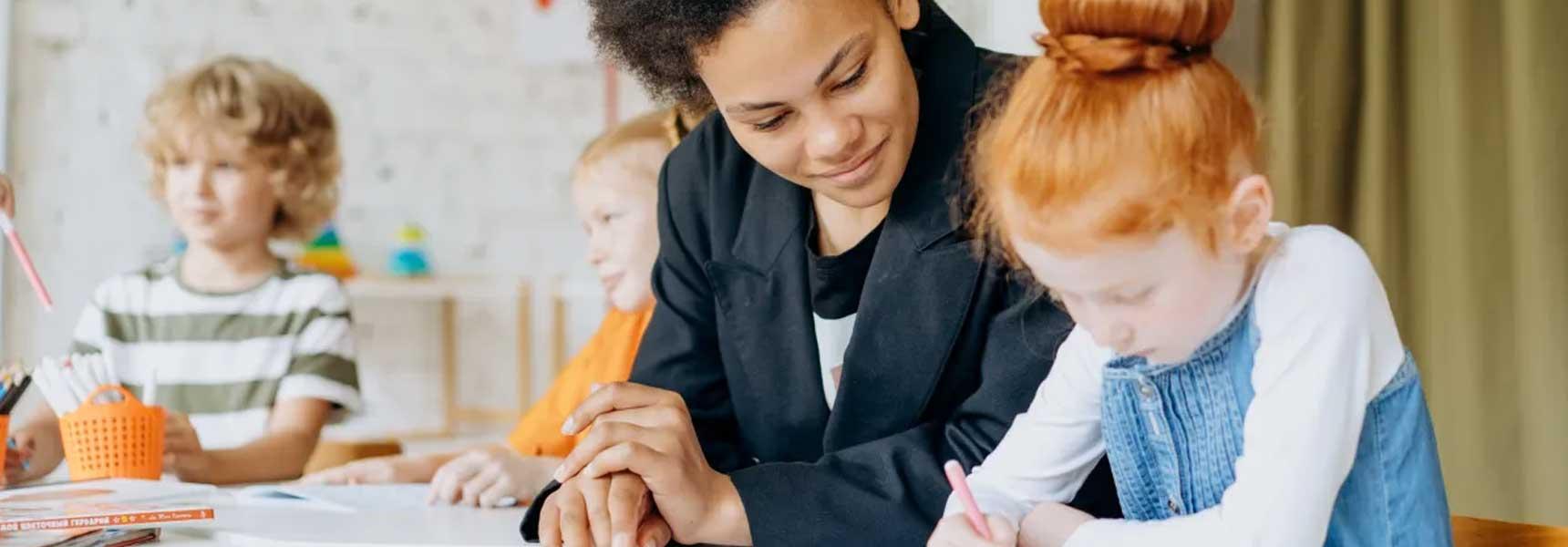 A mentor helping children with a learning activity